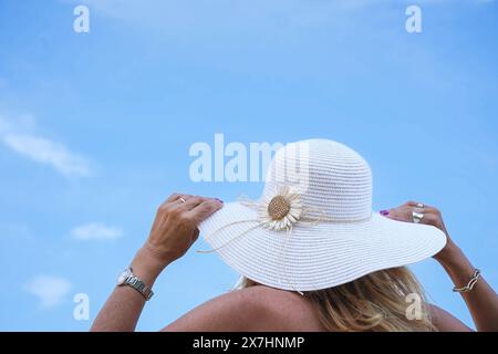 vista posteriore di una donna turistica che indossa un cappello da sole con il cielo blu. Destinazione di viaggio nelle vacanze estive Foto Stock