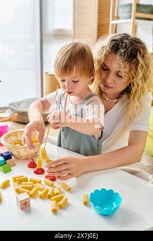 Una madre riccia e sua figlia si impegnano in un'esplorazione giocosa del cibo, abbracciando l'educazione Montessori a casa. Foto Stock