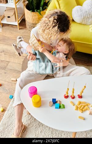 Una madre e sua figlia giocano felicemente con la pasta secca in un accogliente soggiorno pieno di materiali educativi Montessori. Foto Stock