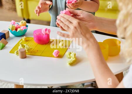 La madre e la figlia si impegnano in un gioco creativo, modellando e modellando l'impasto colorato utilizzando il metodo Montessori. Foto Stock