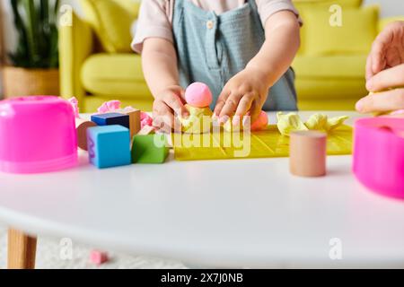 Una mamma guida la sua bambina attraverso Montessori imparando con blocchi colorati e forme. Foto Stock