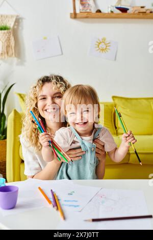 La madre dai capelli ricci e la figlia sono seduti a un tavolo, profondamente concentrati sulle attività di apprendimento Montessori a casa. Foto Stock
