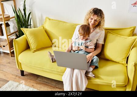 Una madre dai capelli ricci seduta su un divano, che abbraccia sua figlia in un momento caldo e amorevole a casa. Foto Stock