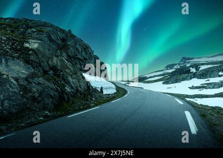 Aurora boreale aurora boreale nel cielo notturno invernale sopra la famosa strada innevata di montagna in Norvegia Foto Stock