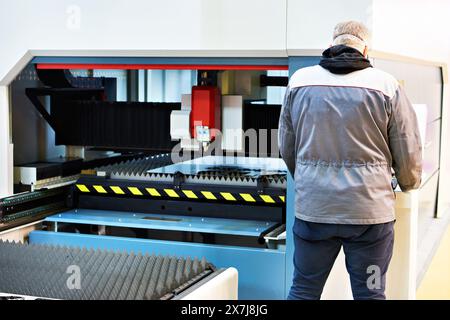 L'uomo lavora su una macchina da taglio laser Foto Stock