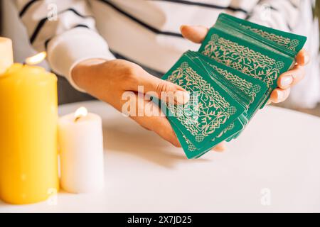 Lady Tarot Reader mescola le carte Tarot davanti alle candele Foto Stock