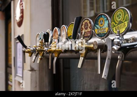 Varsavia, Polonia - 6 agosto 2023: Una linea di rubinetti per birra alla spina installata sulla parete esterna di un pub in strada. Foto Stock