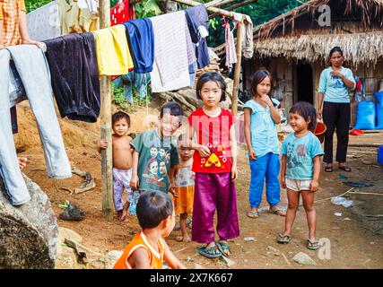 Happy Lahu bambini con lavanderia appesa all'asciugatura in un villaggio vicino a Lanjia Lodge a Chiang Khong nella provincia di Chiang Rai, nel nord della Thailandia Foto Stock