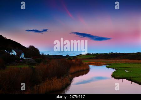 Serata sul fiume Anne, Annestown sulla Copper Coast, Contea di Waterford, Irlanda, con un lontano castello di Dunhill sullo skyline. Foto Stock