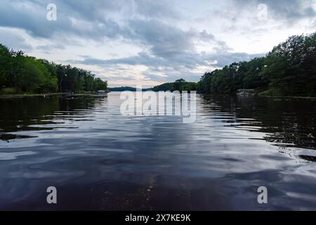 Affacciato su un lago del Wisconsin northwoods mentre gli ultimi raggi di luce del sole iniziano a svanire. Molte barche sono tornate dalla pesca per la sera Foto Stock