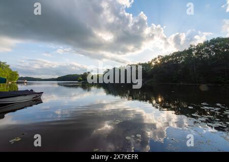 Affacciato su un lago del Wisconsin northwoods mentre gli ultimi raggi di luce del sole iniziano a svanire. Molte barche sono tornate dalla pesca per la sera Foto Stock