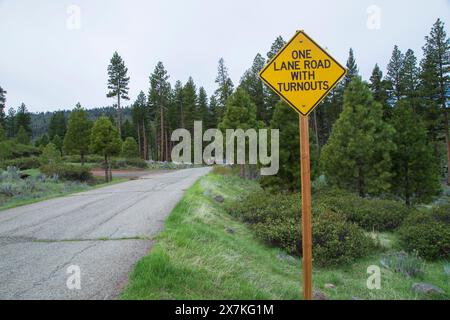 Un cartello vicino a Blue Lake, nella Modoc National Forest, avverte i conducenti che la strada si restringe a una singola corsia che richiede l'uso di curve per il passaggio dei veicoli Foto Stock