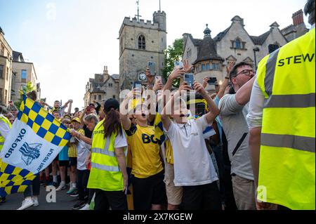 Migliaia di tifosi dell'Oxford United si sono schierati nel centro della città per celebrare la promozione dell'Oxford United al campionato EFL dopo aver battuto i Bolton Wanders nei playoff di League One a Wembley nel fine settimana. La folla, addobbata di giallo, applaudì forte e lasciava sfogarsi gialli mentre l'autobus scoperto che trasportava il team e il personale si muoveva lentamente lungo High Street fino al municipio di Oxford, dove partecipavano a un ricevimento civico solo su invito. La bandiera dell'Oxford United volò sopra l'edificio del Consiglio cittadino di Oxford per festeggiare. Foto Stock