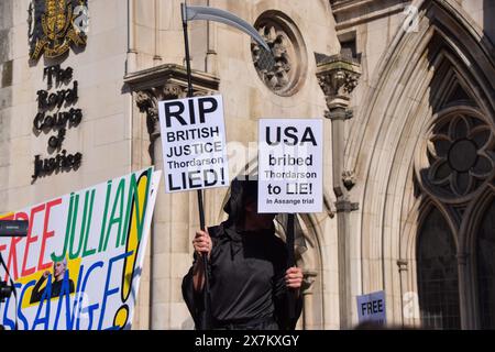 Londra, Regno Unito. 20 maggio 2024. Un sostenitore che indossa un costume Grim Reaper reca cartelli che recano "Rip British Justice" e "USA ha corrotto Thordarson per mentire" durante una protesta fuori dalla High Court prima della decisione di estradizione di Julian Assange. Il fondatore di WikiLeaks ha vinto il diritto di appellarsi alla sua estradizione negli Stati Uniti. Credito: SOPA Images Limited/Alamy Live News Foto Stock