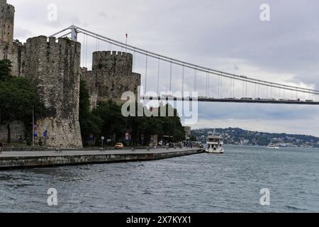 Un castello medievale con una piccola barca sull'acqua di fronte a un ponte, Istanbul, Provincia di Istanbul, Turchia Foto Stock