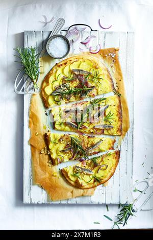 Pizza fatta in casa con patate, sardine, rosmarino e cipolle rosse Foto Stock