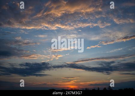Splendida scena al tramonto accentuata da un cielo pieno di nuvole che riflettono varie sfumature di rosa, arancione e blu. Questi colori creano un'impressionante c Foto Stock