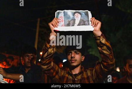 Srinagar, Kashmir. 20 maggio 2024. Un uomo musulmano sciita del Kashmir tiene un ritratto del presidente iraniano Ebrahim Raisi durante una manifestazione che piange la morte del presidente iraniano Ebrahim Raisi, del ministro degli Esteri Hossein Amirabdollahian e di molti altri funzionari. I sostenitori sciiti dell'Iran in molte aree di Srinagar tennero una veglia a lume di candela per piangere la tragica morte del presidente iraniano Ebrahim Raisi, del ministro degli Esteri Hossein Amirabdollahian e di diversi altri funzionari in un incidente in elicottero. Credito: SOPA Images Limited/Alamy Live News Foto Stock