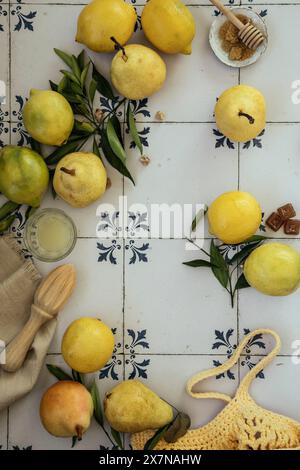 Limoni freschi e pere con foglie. Sacchetto di limoni gialli e pere con foglie di limone fresche su sfondo di piastrelle blu vintage. Piatto Foto Stock