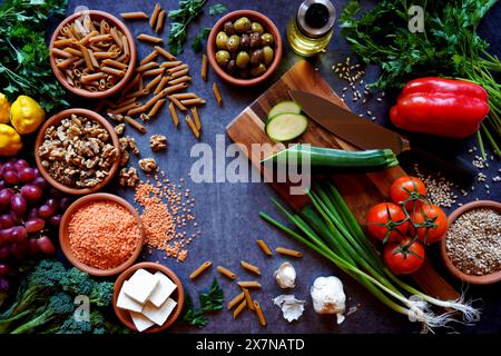 Ingredienti crudi della dieta alimentare completa a base vegetale, tra cui frutta, verdura, cereali, legumi, tofu e noci. Foto Stock