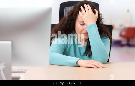 Scatto di una giovane donna d'affari che piange e stressato fuori mentre lavora in un ufficio Foto Stock