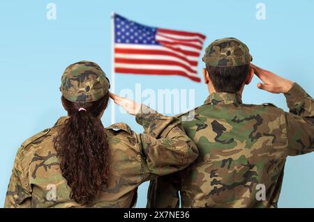 Ripresa della vista posteriore di due soldati americani che salutano la bandiera statunitense. Foto Stock