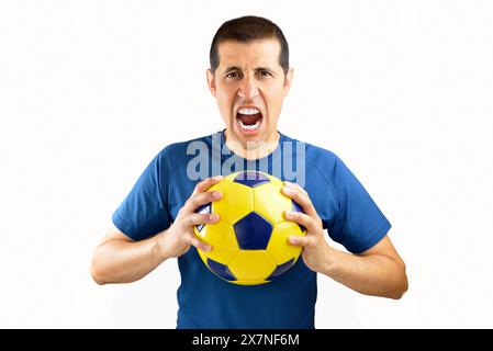 Uomo che regge un pallone da calcio su sfondo bianco isolato urlando orgoglioso e celebrando la vittoria e il successo molto eccitato e tifoso emozione Foto Stock