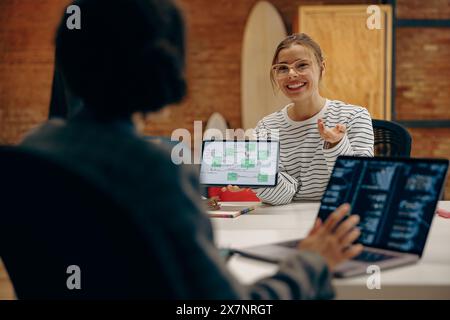 Partner commerciali che si incontrano nel coworking. Colleghi di sesso femminile che discutono su un tablet pc Foto Stock