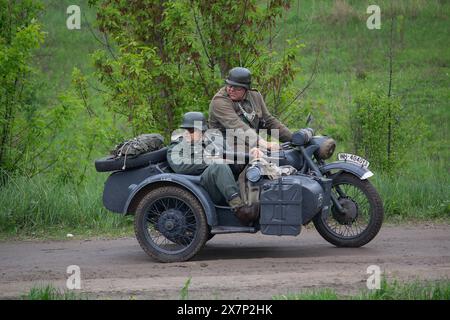 Kiev, Ucraina - 09 maggio 2019: Uomini in abiti di soldati tedeschi su una moto alla ricostruzione storica in occasione dell'anniversario della vittoria i Foto Stock