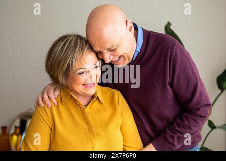 Ritratto di una coppia anziana che condivide un momento tenero, sorridente e si abbraccia a vicenda. Uomo anziano che abbraccia la sua donna, mostrando affetto. Foto Stock