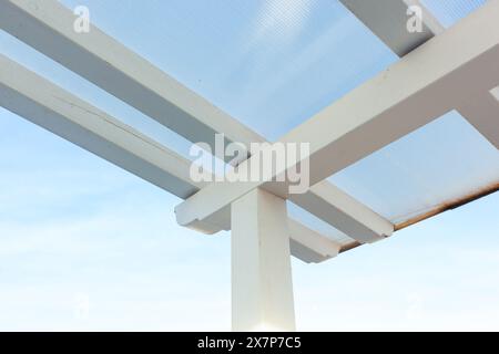 Copertura in legno e ondulato. Baldacchino montato su terrazza con tavole di legno bianche. Foto Stock