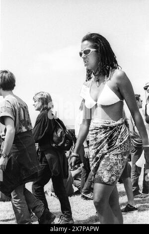 CROWD, HEATWAVE, NME STAGE, GLASTONBURY 95: Una donna in tonalità bianche, bikini bianco e gonna tie-die anni '90 al secondo NME Stage Field e folla al Glastonbury Festival, Pilton Farm, Somerset, Inghilterra, 24 giugno 1995. Nel 1995 il festival ha celebrato il suo 25 ° anniversario. Molte persone hanno lottato con il colpo di calore nel weekend particolarmente caldo. Foto: ROB WATKINS Foto Stock