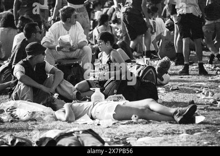 CROWD, HEATWAVE, NME STAGE, GLASTONBURY 95: I frequentatori del Festival si schiantano sull'erba nell'estrema ondata di caldo estiva al secondo NME Stage Field e folla al Glastonbury Festival, Pilton Farm, Somerset, Inghilterra, 24 giugno 1995. Nel 1995 il festival ha celebrato il suo 25 ° anniversario. Molte persone hanno lottato con il colpo di calore nel weekend particolarmente caldo. Foto: ROB WATKINS Foto Stock