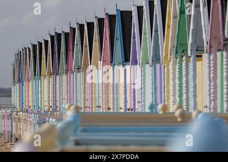 Graziose capanne colorate sulla spiaggia di West Mersea nell'Essex nel Regno Unito. Foto Stock