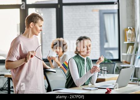 Belle e diverse donne d'affari che discutono il loro progetto in ufficio. Foto Stock