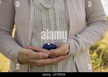 mani donna che tiene la candela blu. Meditazione. Relax. aromaterapia. concetto. Orizzontale Foto Stock