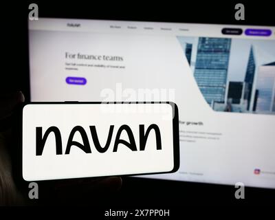 Persona che possiede uno smartphone con il logo della società americana di software per la gestione dei viaggi Navan Inc. Davanti al sito Web. Mettere a fuoco il display del telefono. Foto Stock