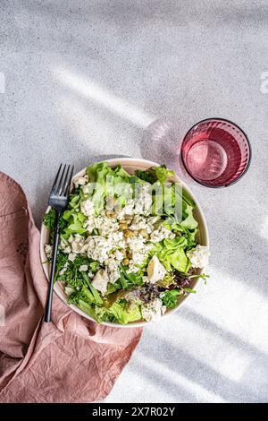 Un'insalata nutriente di mix di erbe contenente lattuga, cipolla verde, prezzemolo, dragoncello, capperi fermentati, e formaggio brie blu sbriciolato, condito con olive o Foto Stock
