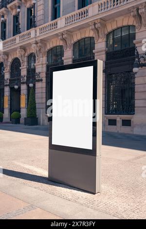 Un modello verticale di un cartellone bianco in una giornata di sole con l'architettura ornata di Madrid sullo sfondo Foto Stock