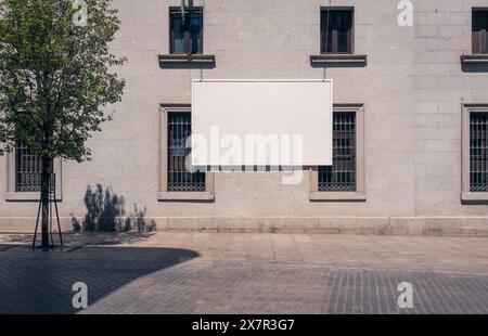 Un grande cartellone bianco è appeso alla parete esterna di un edificio a Madrid, perfetto per i mockup pubblicitari Foto Stock