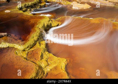 Scatto a lunga esposizione che cattura le uniche e vibranti tonalità arancioni e i verdi muschiati del fiume Riotinto, in Spagna, mettendo in risalto l'impressionante bellezza naturale a. Foto Stock