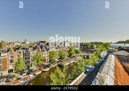 Una vibrante vista aerea di Amsterdam che mostra l'architettura iconica e i vivaci canali sotto un cielo azzurro, questa immagine cattura l'essenza di ci Foto Stock