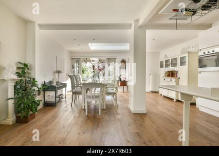 Un invitante spazio abitativo open space situato a Schaarweg, Amsterdam, con cucina moderna, elegante zona pranzo e pavimenti in legno massiccio Foto Stock