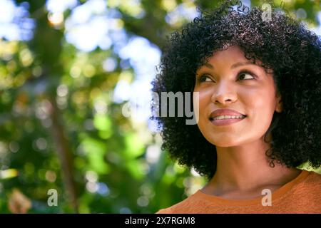 Testa e spalle Ritratto di donna adulta sorridente e sicura di sé in piedi all'aperto Foto Stock
