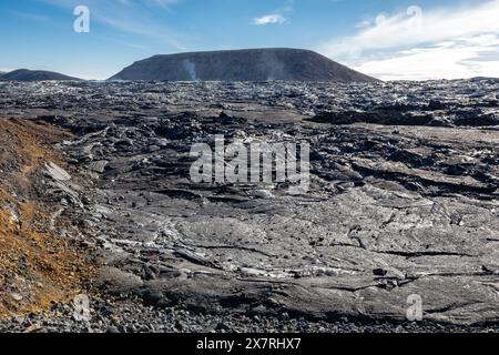 Campo lavico del vulcano Fagradalsfjall con lava basaltica congelata creata dopo l'eruzione, sfiati fumanti e nuovo cono del cratere, Islanda. Foto Stock