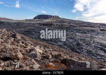 Paesaggio del campo lavico del vulcano Fagradalsfjall con lava basaltica congelata creata dopo l'eruzione, sfiati fumanti e nuovo cono cratere, Islanda. Foto Stock