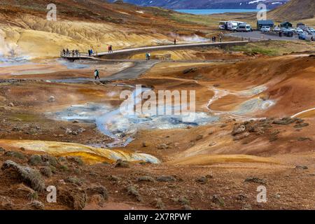 Krysuvik, Islanda, 14.05.22. Area geotermica di Seltun a Krysuvik con sorgenti termali fumanti, colline di zolfo gialle e arancioni, persone che camminano. Foto Stock