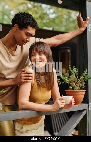 Un uomo e una donna stanno insieme su un balcone, godendosi un momento romantico. Foto Stock