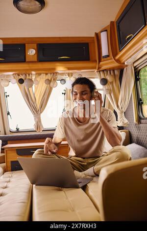 Un libero professionista con un notebook può sedersi comodamente su un divano, in viaggio di lavoro o di piacere. Foto Stock