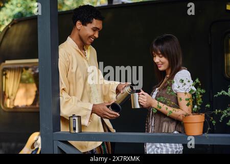Un uomo e una donna si stagliano su un balcone, ammirando la vista mozzafiato davanti a loro durante una fuga romantica. Foto Stock